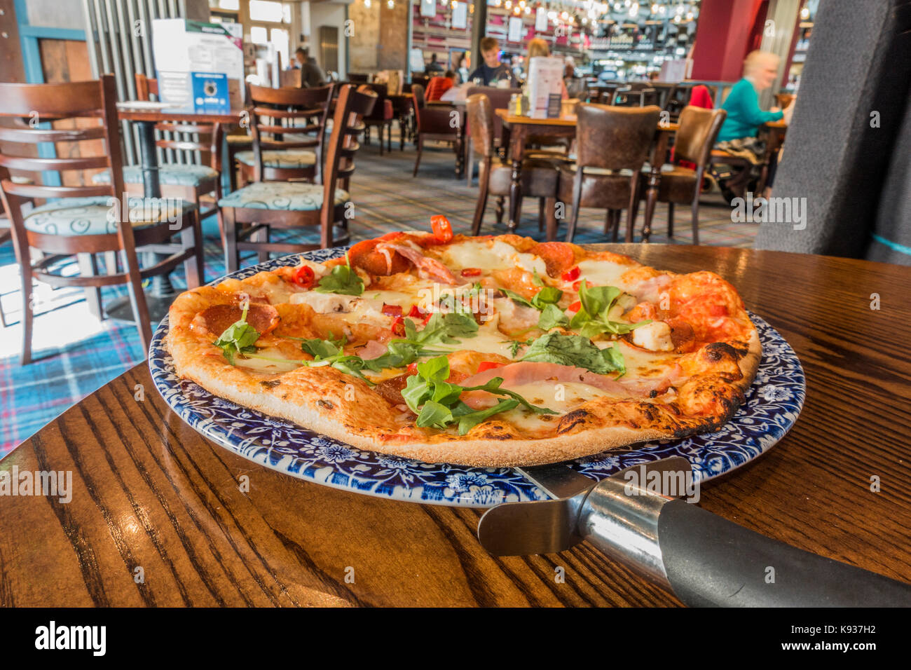 Pizza Fresca appena servita su un tranquillo pomeriggio a JD Wetherspoon pub ristorante (spesso chiamato Wetherspoons), Stamford, Lincolnshire, Inghilterra, Regno Unito. Foto Stock