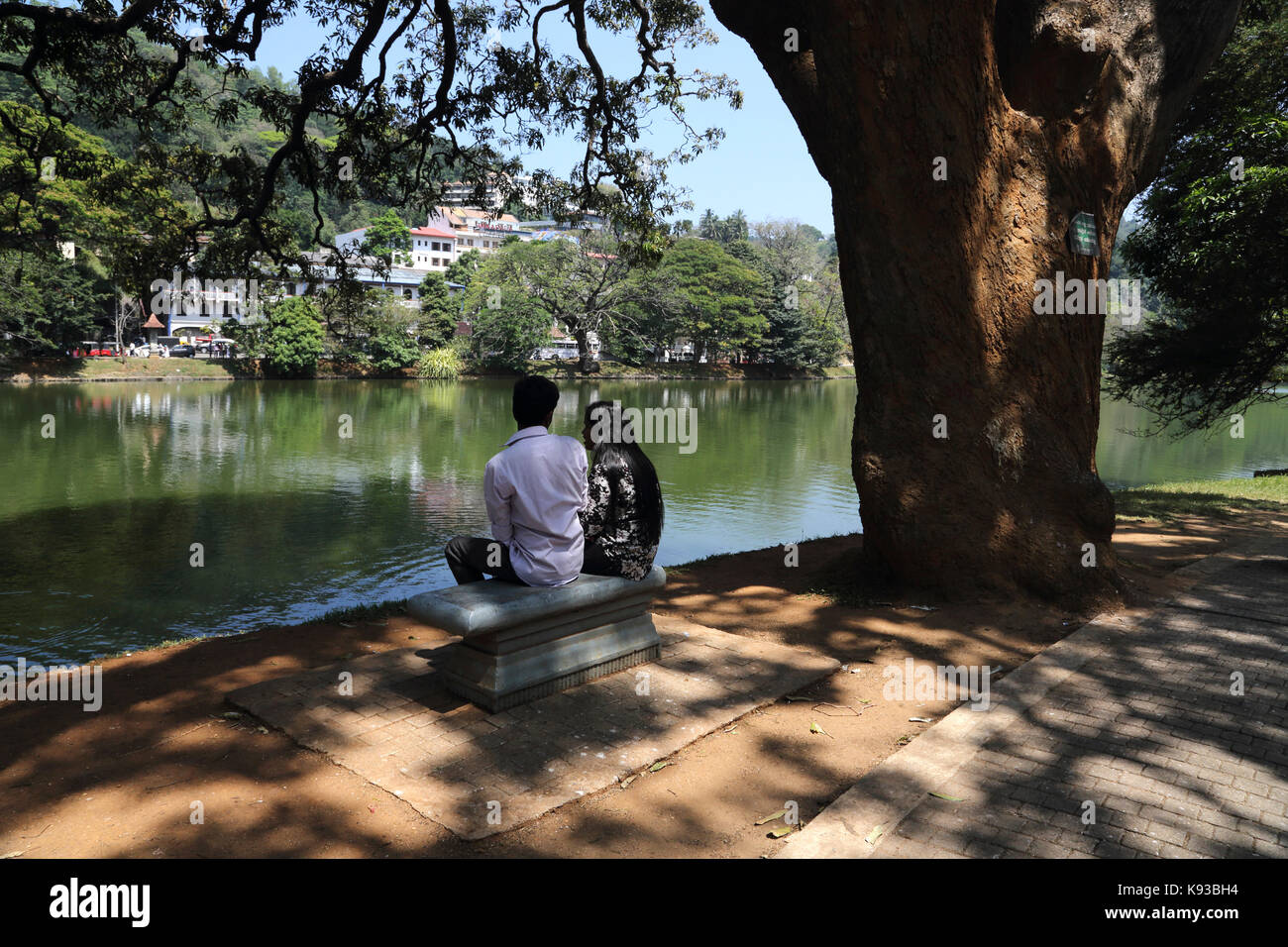 Kandy Sri Lanka giovane seduto da Lago Kandy Kiri Muhuda grande lago artificiale creato nel 1807 da Sri Wickrama Rajasinha Foto Stock