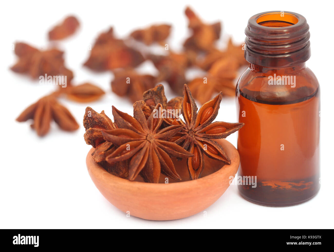 Aromatica anice stellato con olio essenziale in una bottiglia su sfondo bianco Foto Stock