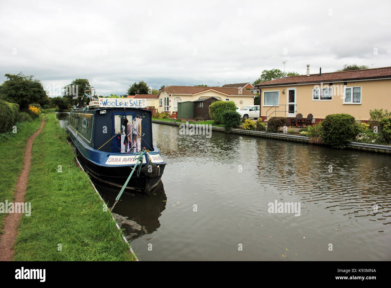 Emma maye ormeggiata in penkridge 4.9.17. La stretta barca "emma maye" è ormeggiata lungo l'alzaia del Canale di fronte ad un sviluppo di case del parco. Foto Stock