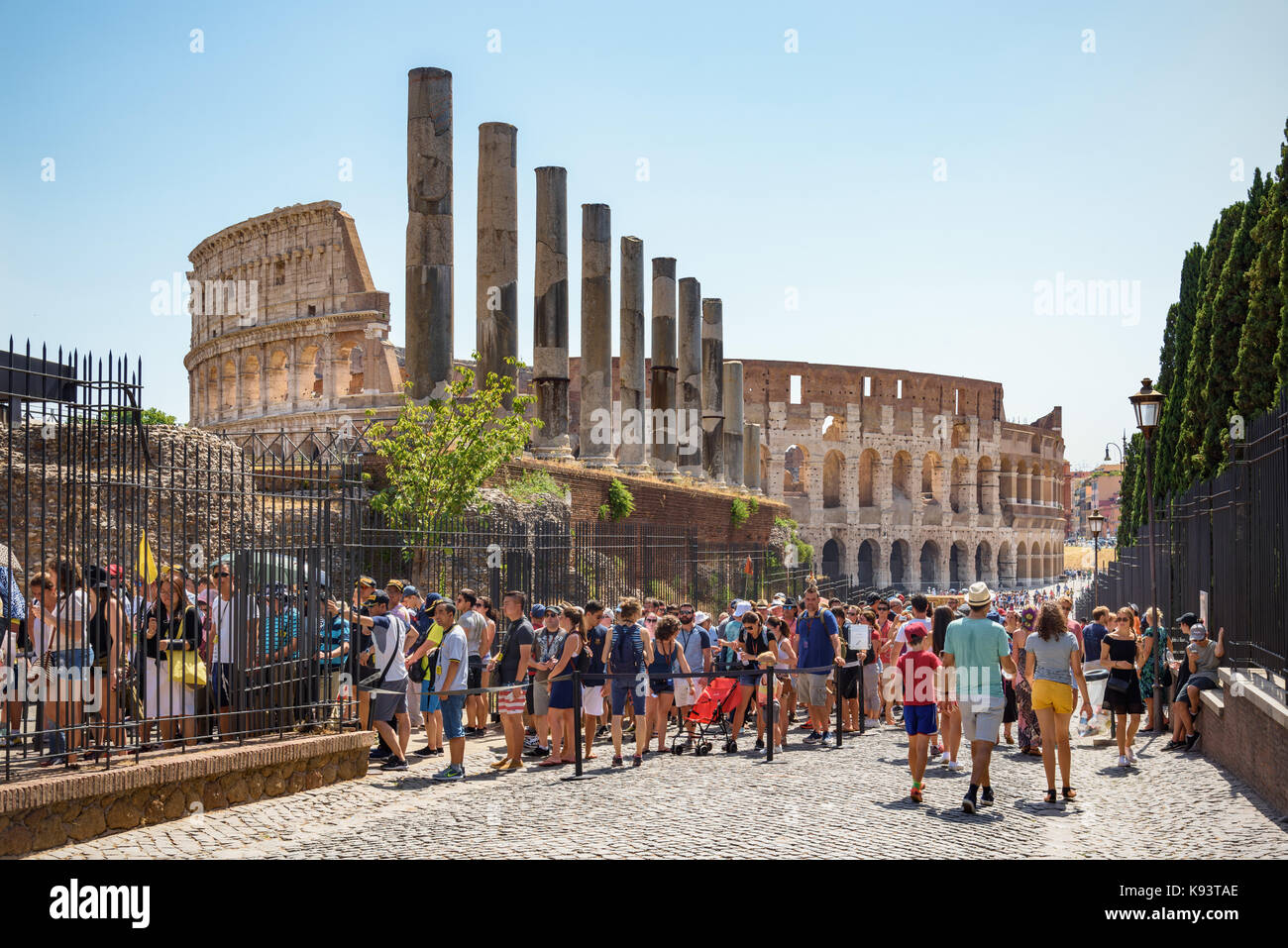Orde di turisti in coda sulla Via Sacra per accedere al forum, al Colosseo in background, Roma, Italia Foto Stock