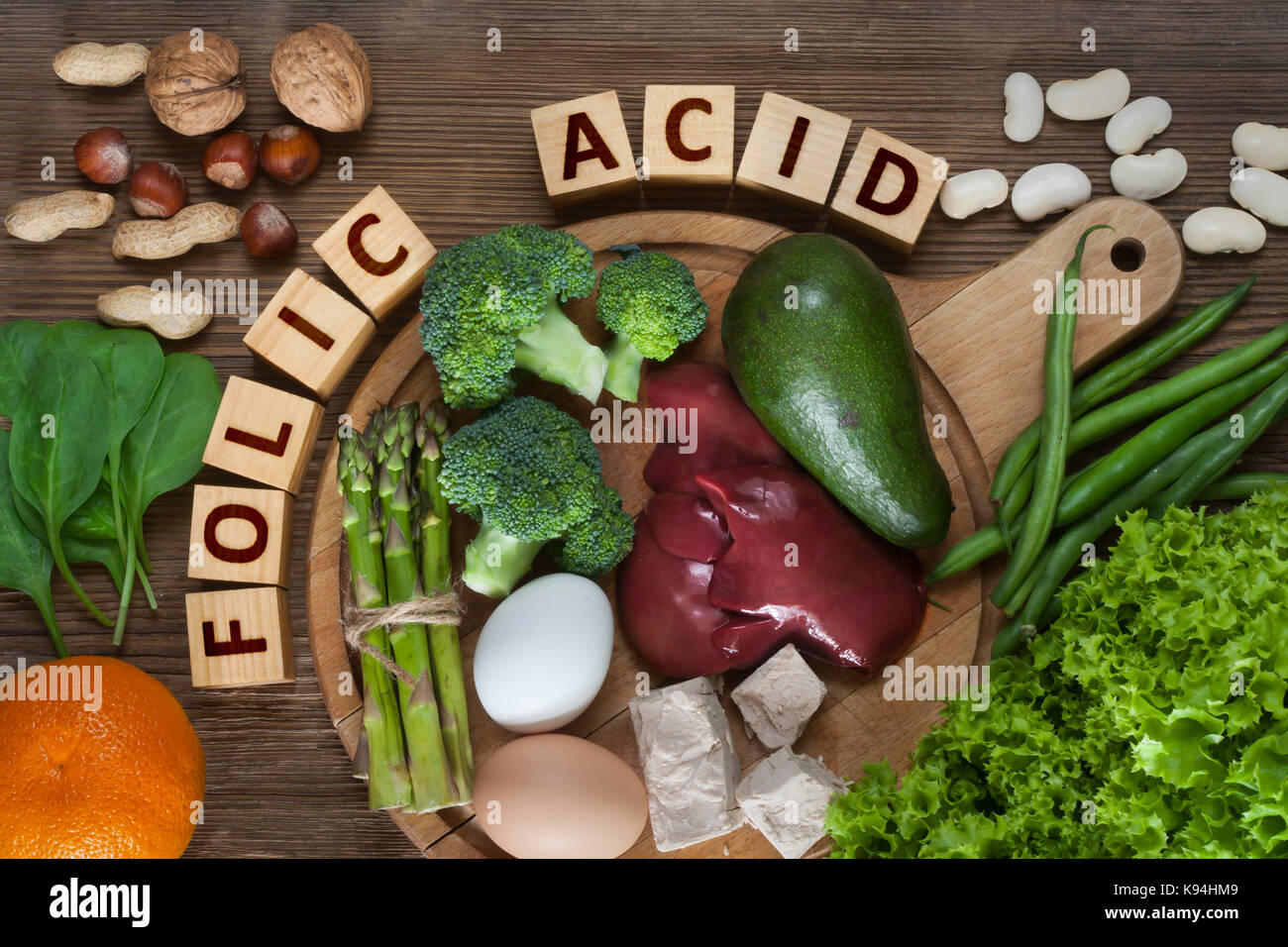 Fonti naturali di acido folico come fegato, asparagi, broccoli, uova, insalata di avocado, lievito, dadi, spinaci, arancione e fagioli Foto Stock