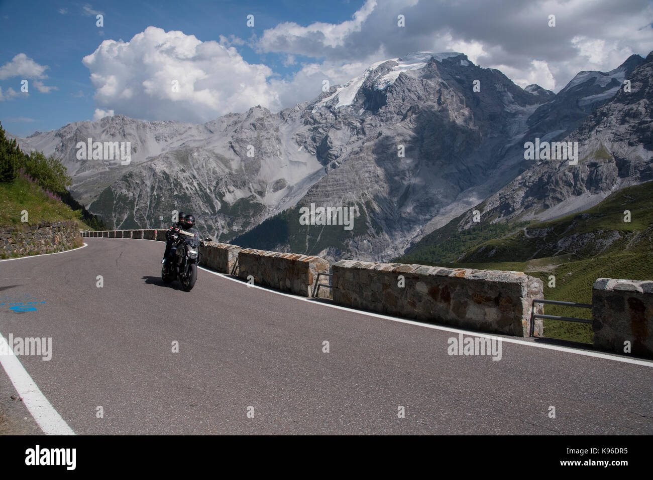 Motociclista sul Passo dello Stelvio, con 76 pin per capelli si piega uno dei migliori strada nel mondo e un Alpine ultra high pass, dall'Italia alla Svizzera Foto Stock