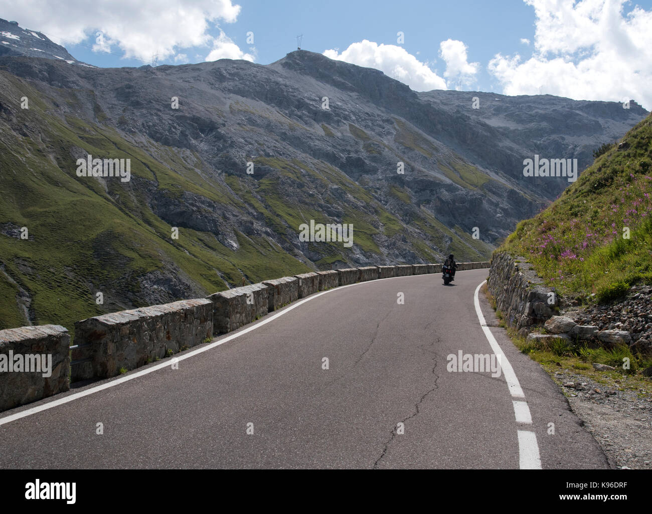 Motociclista sul Passo dello Stelvio, con 76 pin per capelli si piega uno dei migliori strada nel mondo e un Alpine ultra high pass, dall'Italia alla Svizzera Foto Stock
