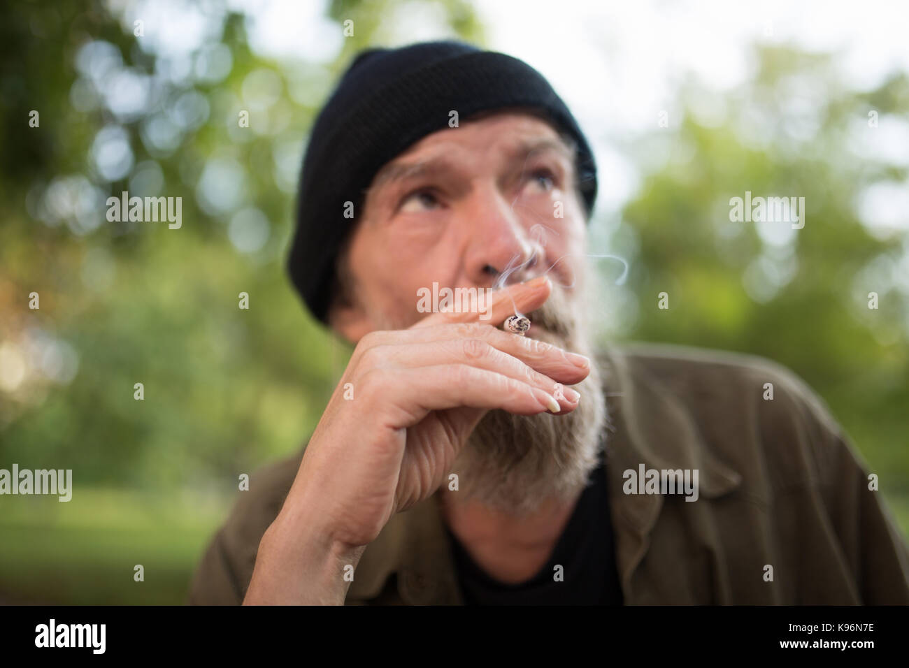 Vista ravvicinata di vecchio uomo fumatori. Foto Stock