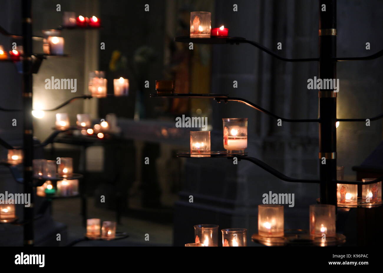 Messa a fuoco poco profonda colpo di candele votive su un cavalletto in una chiesa cattolica Foto Stock