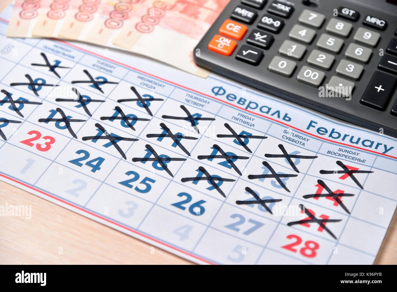 Calcolatrice elettronica, banconote di cinque mila rubli, calendario con le vacanze in giorno di febbraio 23 sono sul tavolo. business still life Foto Stock