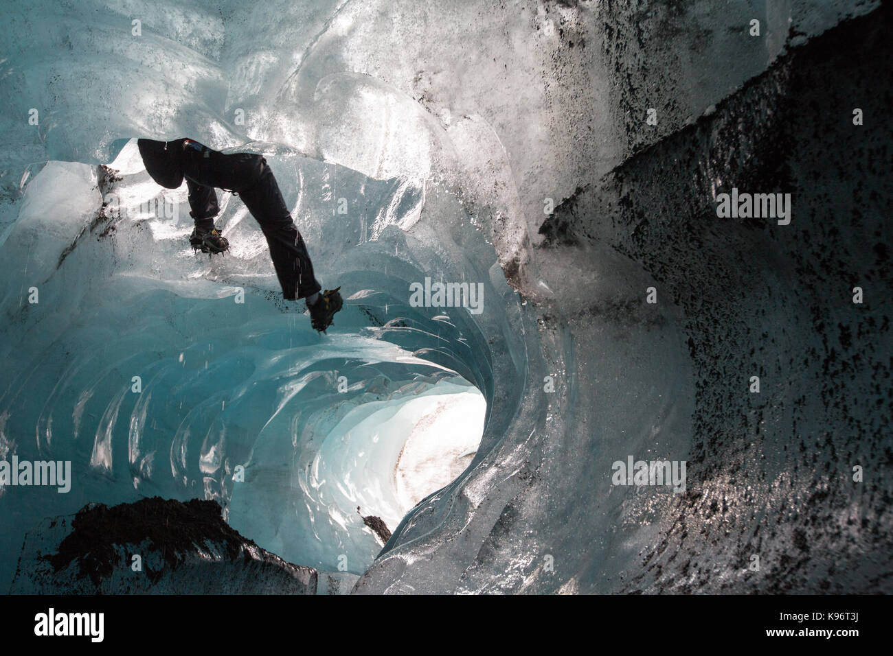 Un scalatore discende dalla fune in un moulin sul ghiacciaio Skaftafell. Foto Stock