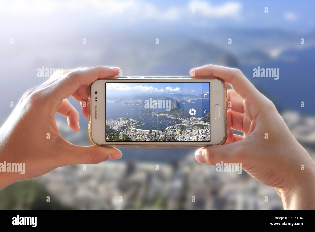 Donna che scatta una foto di Rio. Fotocamera di uno smartphone. Visualizza attraverso lo schermo il momento in cui una giovane donna scatta la foto. Città di Rio de Janeiro. Foto Stock