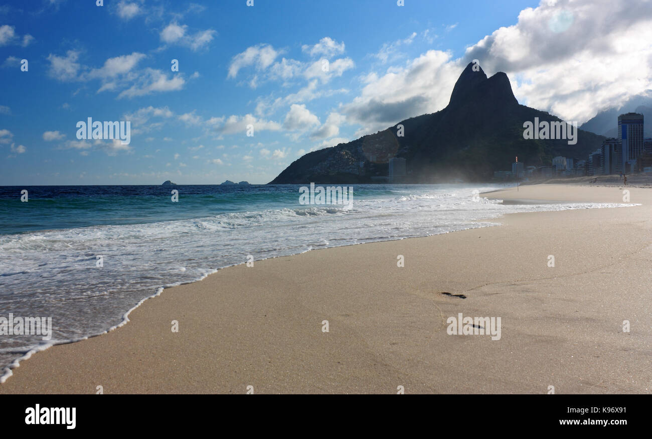 Pomeriggio presso la spiaggia di Ipanema, Rio de Janeiro, Brasile. Il mare, la spiaggia, il cielo blu con nuvole e la collina di due fratelli in background. Foto Stock