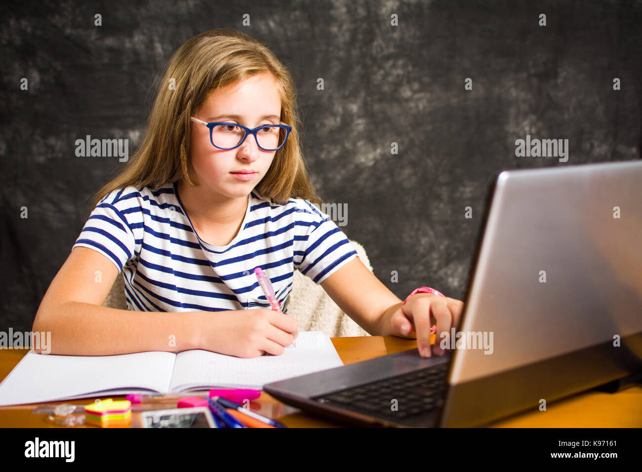 Annoiato ragazza adolescente facendo compiti a casa Foto Stock