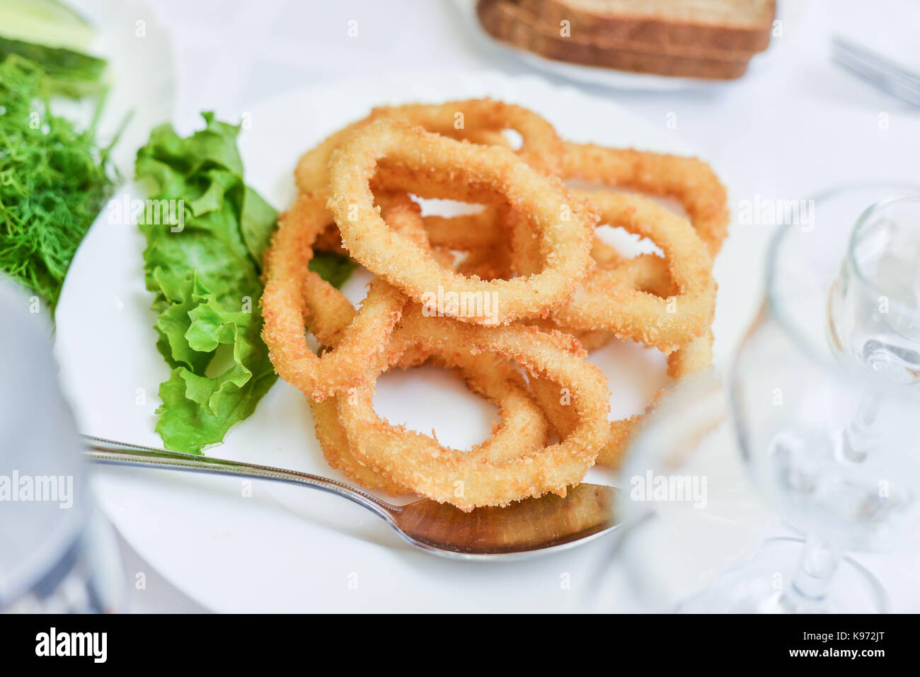 Deep pastella fritti anelli di totano Calamari con insalata verde sulla  piastra Foto stock - Alamy