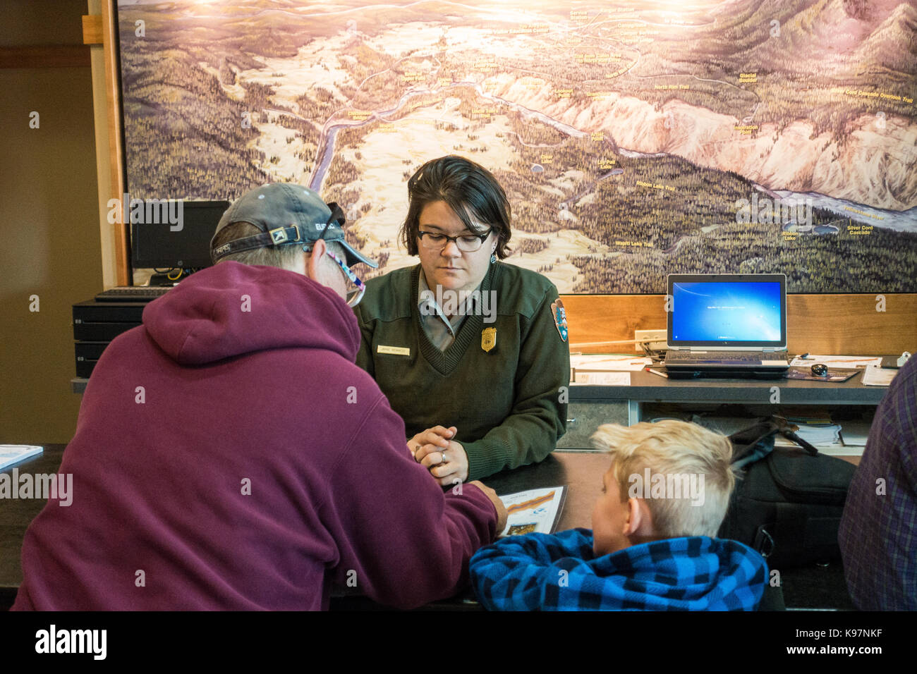 Dipendente del parco / ranger del Parco Nazionale di Yellowstone tenendo dando un parco / informazioni di trail a turisti e visitatori Foto Stock