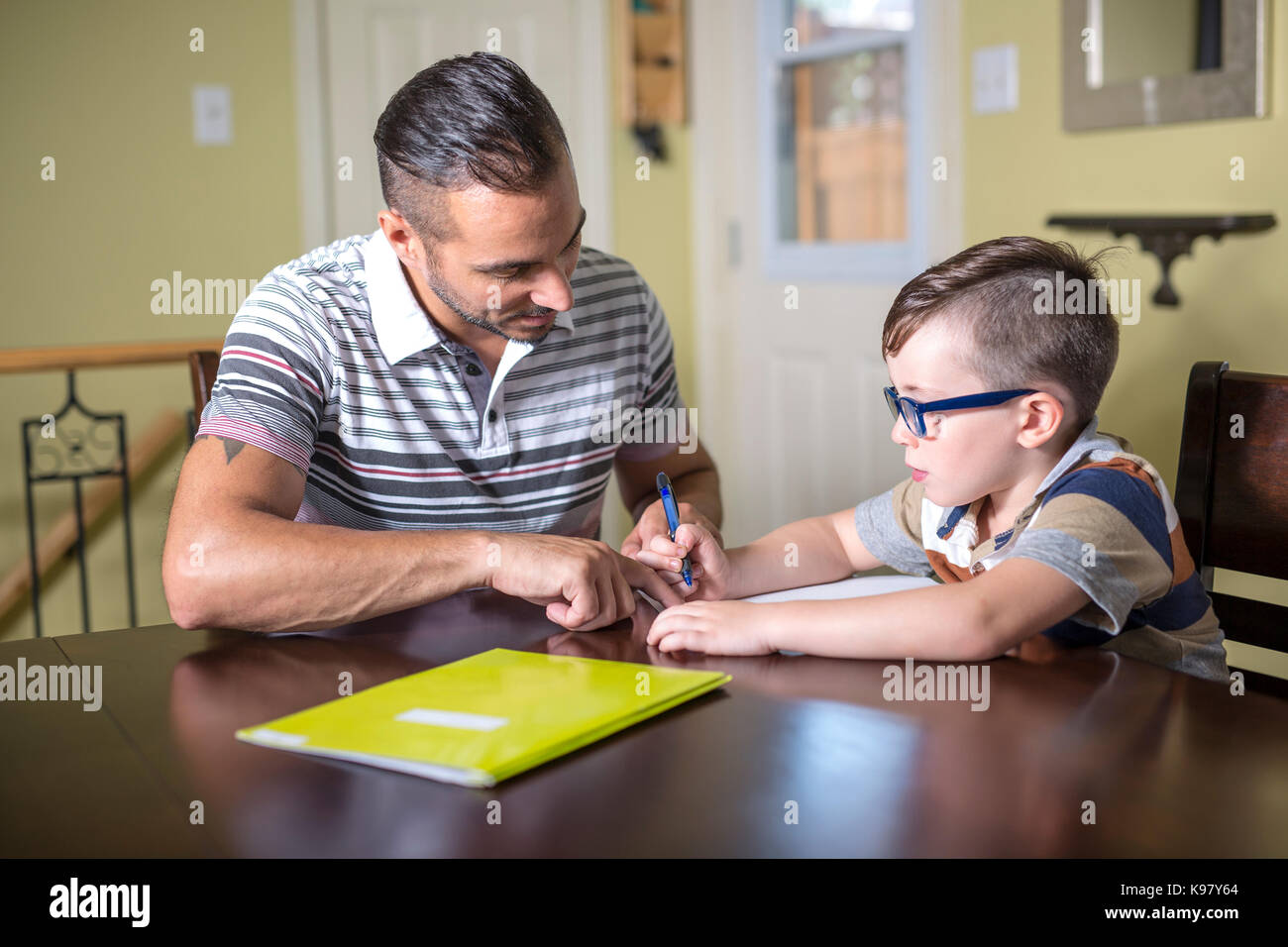 Padre aiutando figlio fare i compiti. genitore aiuta il suo bambino Foto Stock
