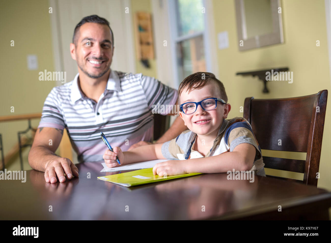 Padre aiutando figlio fare i compiti. genitore aiuta il suo bambino Foto Stock