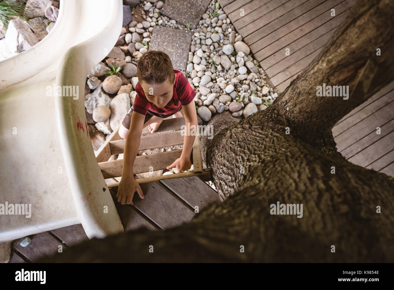 Sovraccarico di boy scaletta di arrampicata in parco giochi Foto Stock