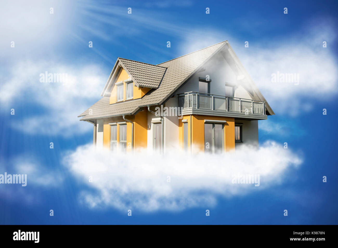 Casa vola nella luce del sole su una nuvola in cielo. Foto Stock