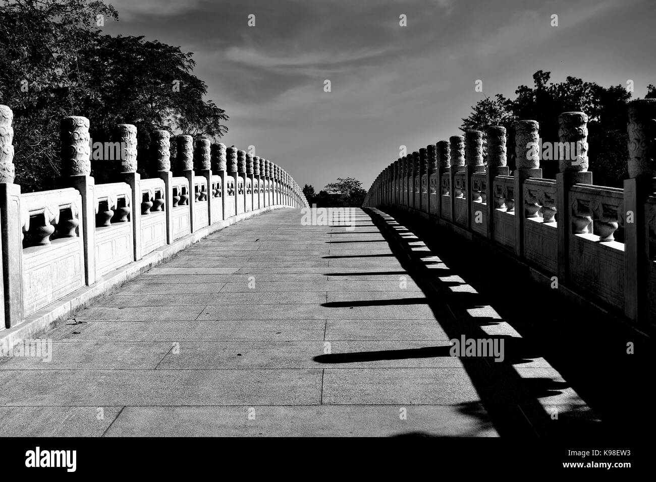 Vista la carreggiata e abbellita da balaustre del ponte di pietra a giardini cinesi, Singapore Foto Stock