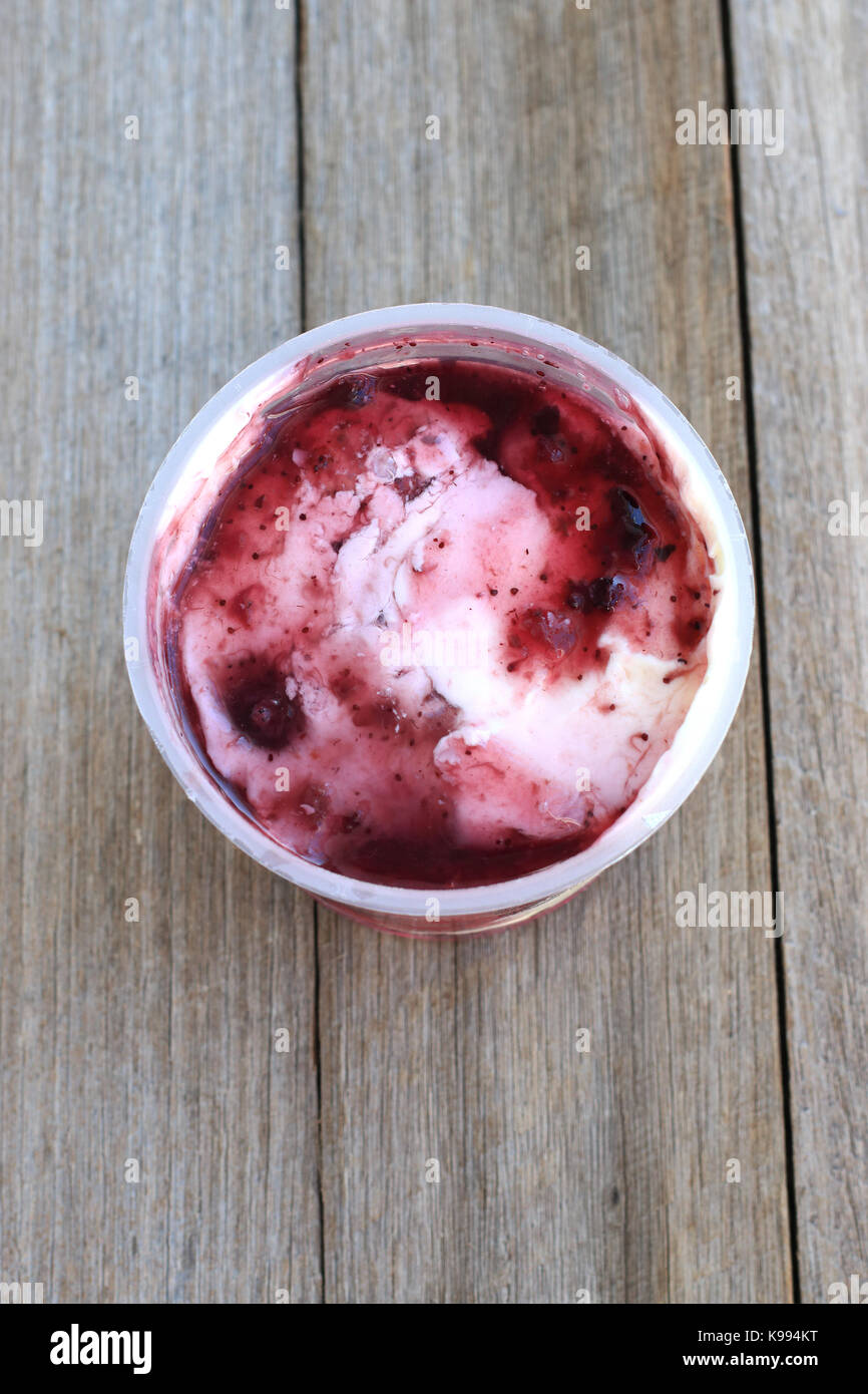 Berry yogurt aromatizzati contro lo sfondo di legno Foto Stock