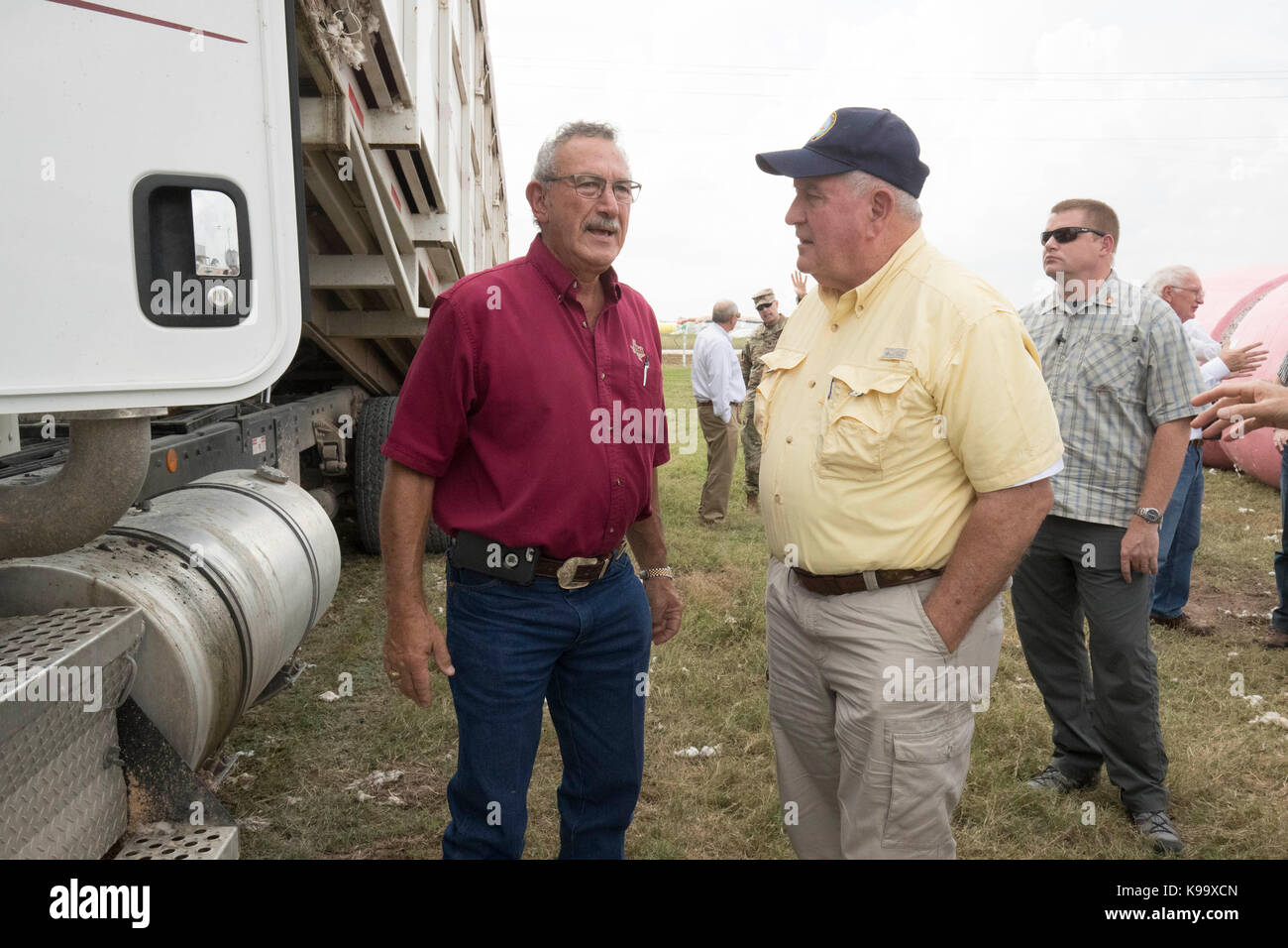 El campo, Stati Uniti. 21 Settembre 2017. Il Segretario dell'Agricoltura degli Stati Uniti Sonny Perdue (camicia gialla) tours una fattoria di cotone devastato dall'uragano Harvey tre settimane fa. In camicia rossa è il compratore di cotone Johnny Ropolo. Credit: Bob Daemmrich/Alamy Live News Foto Stock