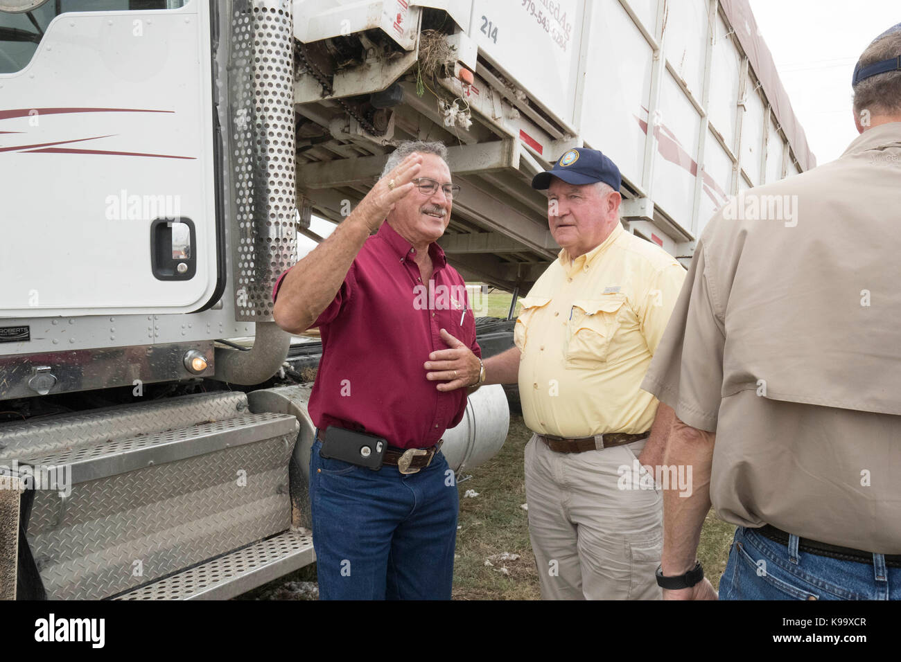 El campo, Stati Uniti. 21 Settembre 2017. Il Segretario dell'Agricoltura degli Stati Uniti Sonny Perdue (camicia gialla) e il Presidente dell'Agricoltura della Casa Mike Conaway (TAN) tour un gin di cotone dopo aver incontrato gli agricoltori le cui colture di cotone sono state devastate dall'uragano Harvey tre settimane fa. In camicia rossa è il compratore di cotone Johnny Ropolo. Credit: Bob Daemmrich/Alamy Live News Foto Stock