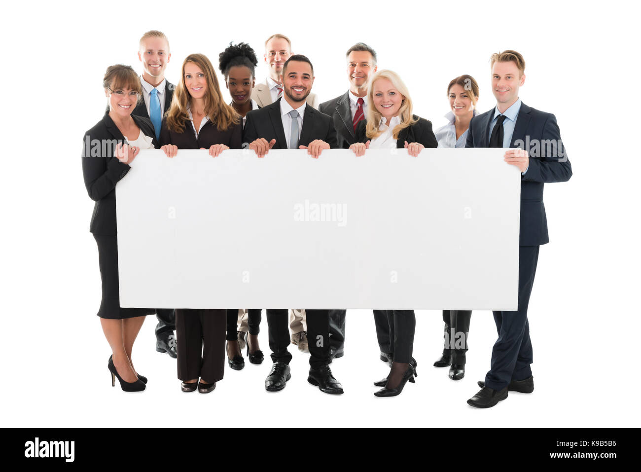 Ritratto di fiducioso multi etnico team business azienda tabellone vuoto contro uno sfondo bianco Foto Stock