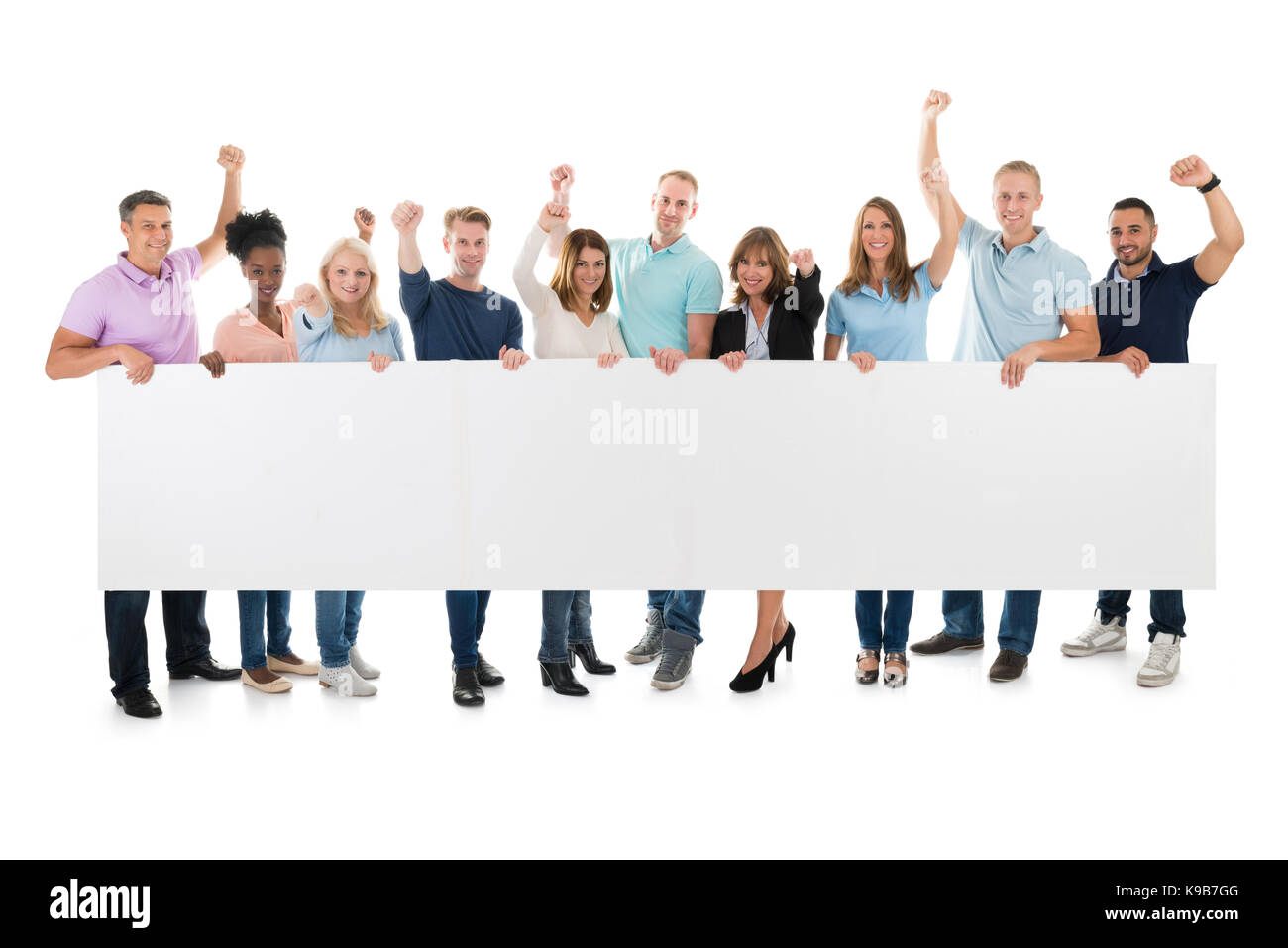 A piena lunghezza Ritratto di felice team con bracci sollevati holding tabellone vuoto contro uno sfondo bianco Foto Stock