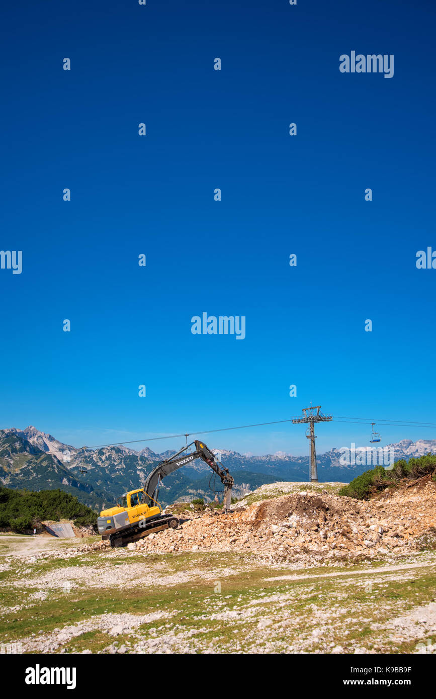 Vogel mountain, Slovenia - 30 agosto 2017: costruzione di macchinari per la frantumazione di pietra, volvo bulldozer lavorando sul pendio di montagna Foto Stock