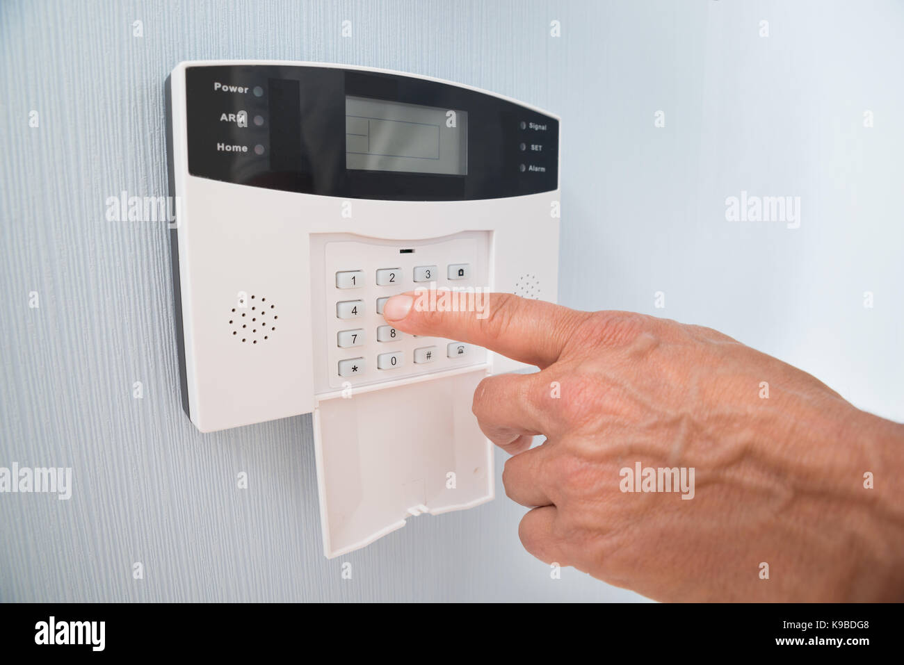 Close-up di mano di una persona inserendo il codice nel sistema di sicurezza Foto Stock