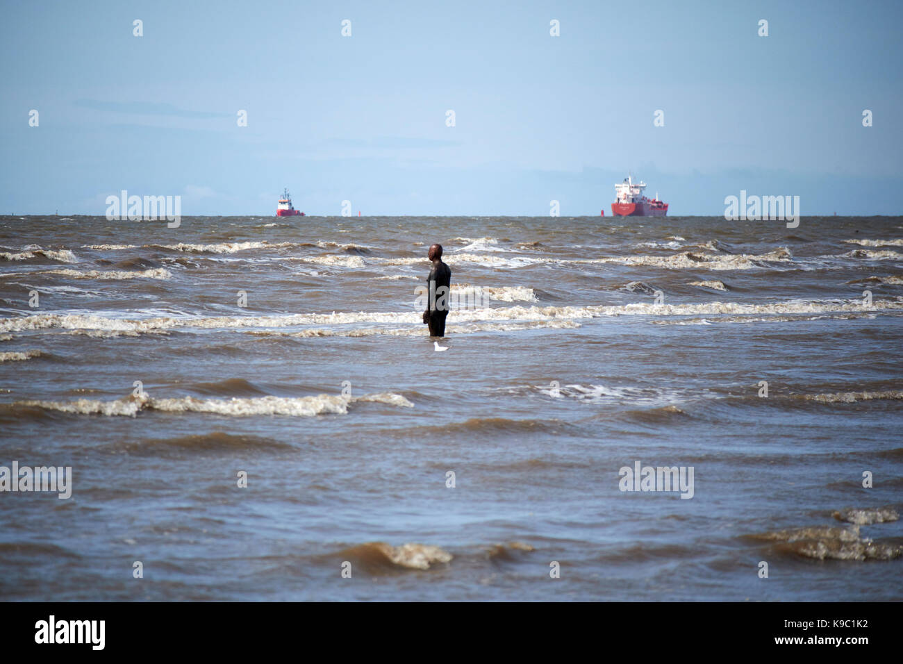 Anthony gormleys un altro luogo sulla Crosby beach parte del crosby parco costiero liverpool liverpool con canale di spedizione in background Foto Stock