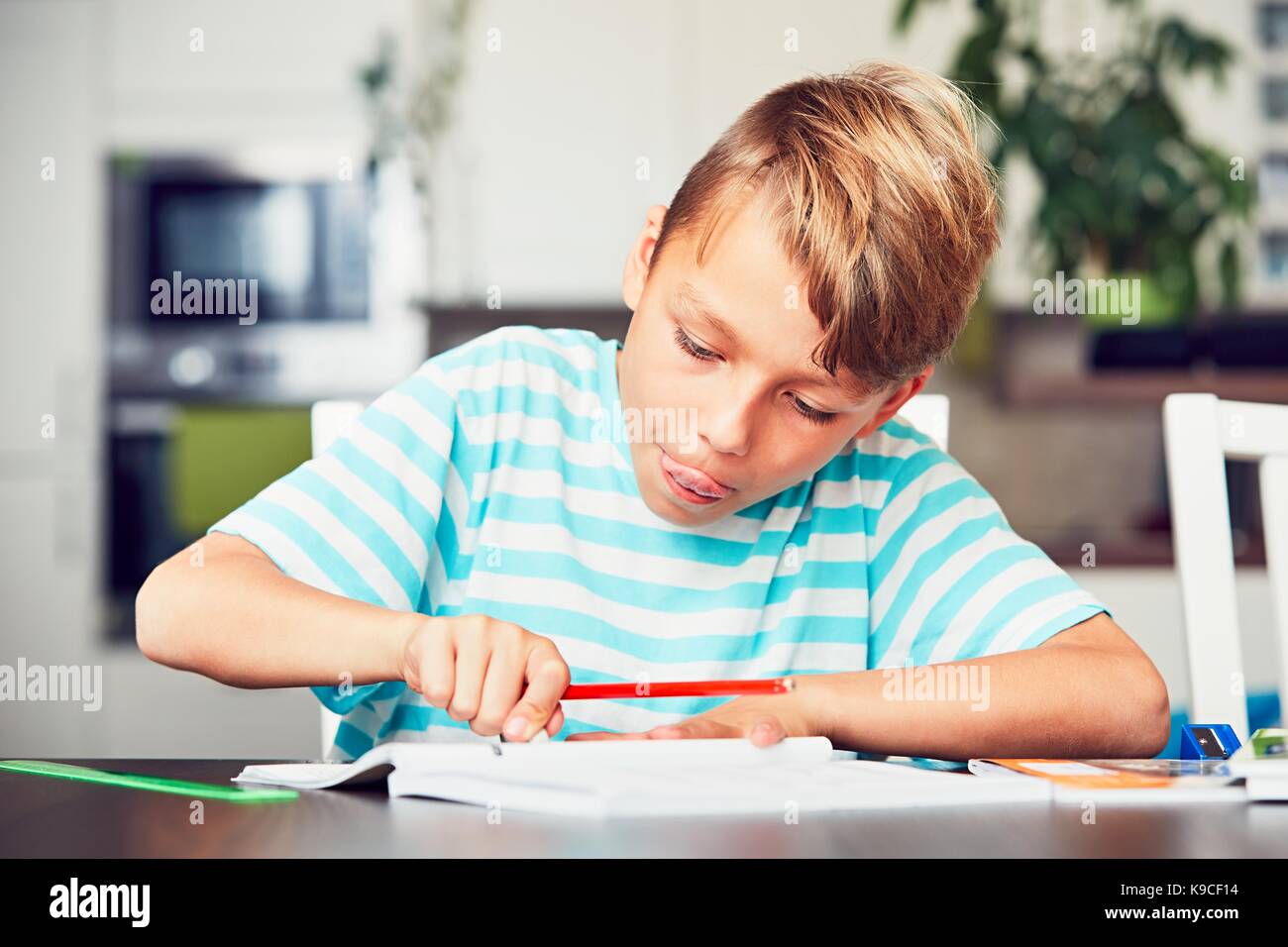 Little Boy iscritto i suoi compiti per la scuola elementare. Foto Stock