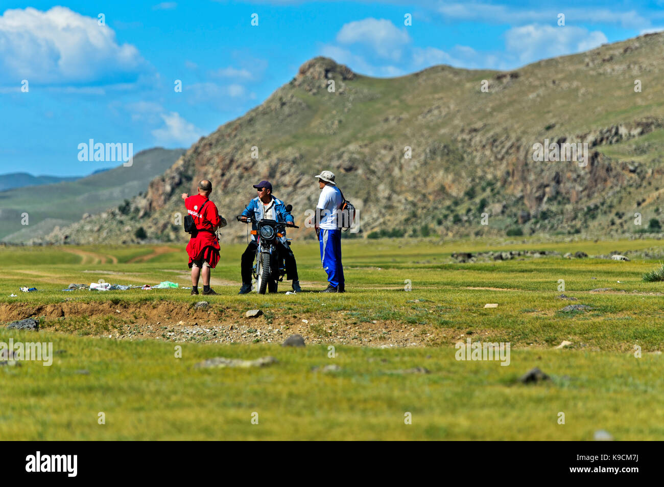 Motor-biker chiedendo a due uomini per la direzione nella steppa, orkhon valley, Khangai Nuruu national park, oevoerkhangai aimag provincia, Mongolia Foto Stock