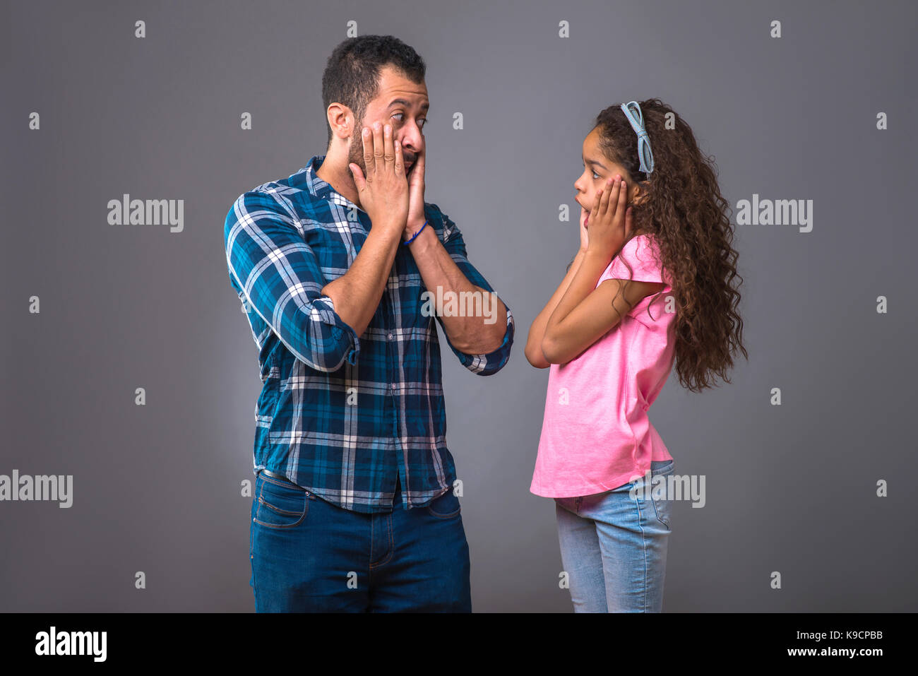 Un giovane uomo nero in piedi con sua figlia e hanno entrambi sorpresi Foto Stock