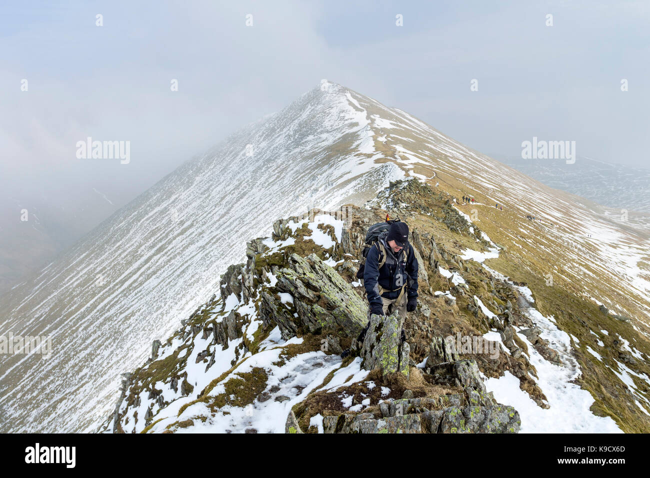 Walker rendendo il loro modo al di sopra di bordo Swirral con la montagna di camma Catstye dietro, gamma Helvellyn, Lake District, Cumbria, Regno Unito Foto Stock