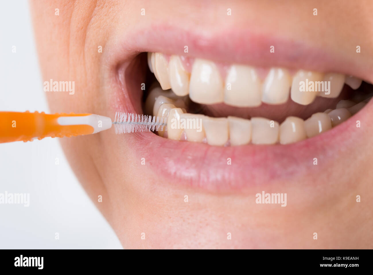 Donna di pulizia dei denti di lei con uno scovolino interdentale Foto stock  - Alamy