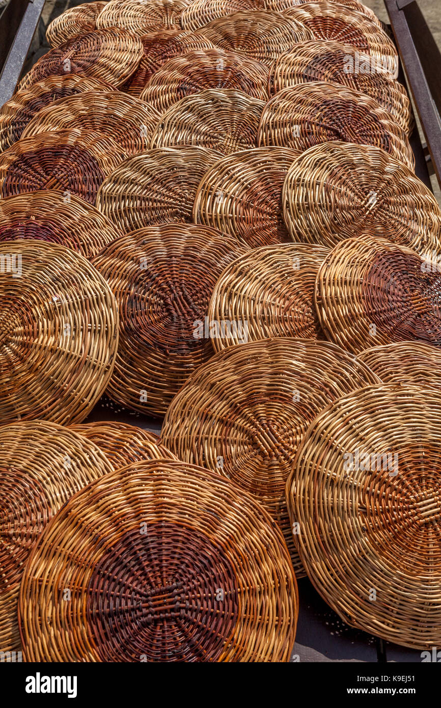 Pile di round, reed, tessuti picnic titolari della piastra. Foto Stock