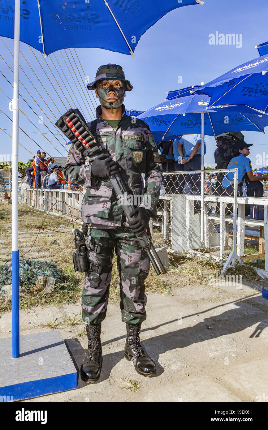 Un Philippine National poliziotto dalla barca speciale unità (SBU) Sta di guardia a una funzione pubblica tenendo un Tactical Assault fucile a Puerto Principe Foto Stock