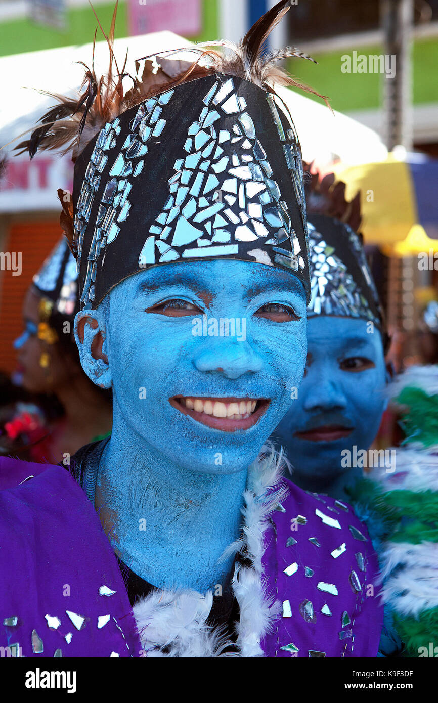 Ritratto di un adolescente filippino scolaro con il suo volto dipinto di blu che indossa il suo nativo costume tribali per il multi-culturale di festival che si tiene ogni anno Foto Stock
