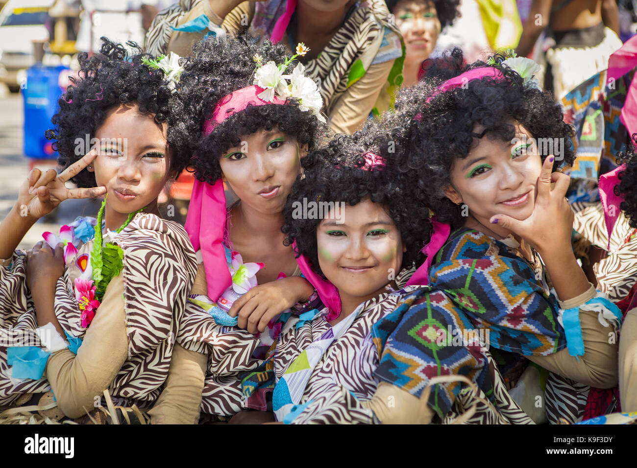 Quattro asiatici filippino di alta scuola le ragazze sono vestite di nero, curley capelli Parrucche e costumi che riflettono il loro etnici tribali background all'anuale multi Foto Stock