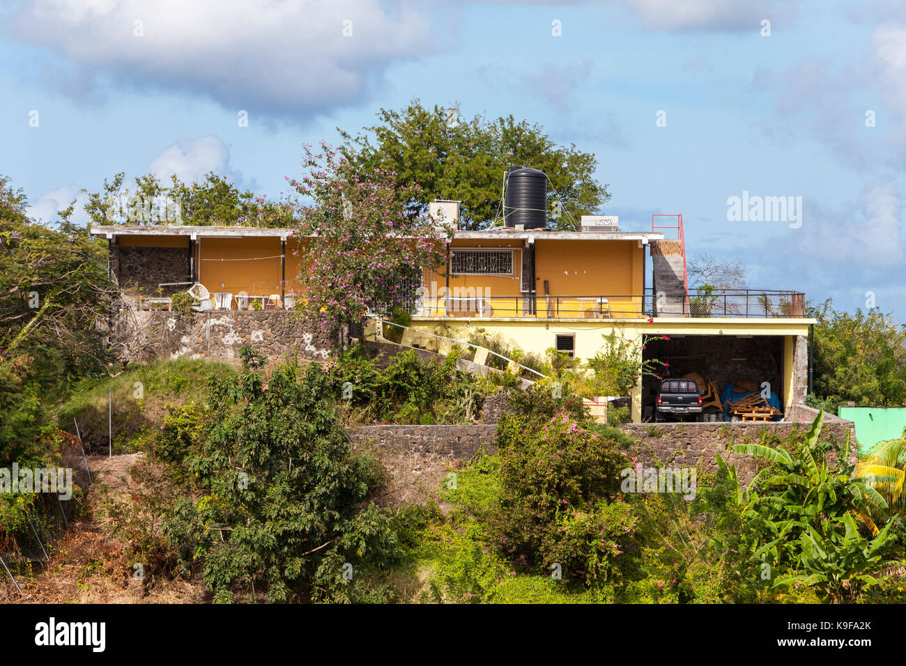Castries, Santa Lucia. Middle-class house con acqua serbatoio di accumulo sul tetto. Foto Stock