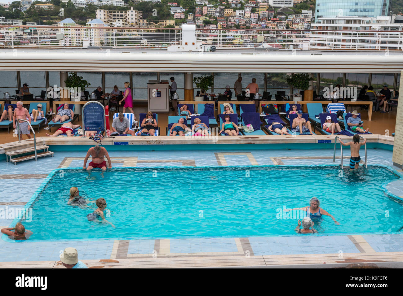 Crociera nei Caraibi nave passeggeri relax intorno alla piscina a bordo piscina. Fort-de-France, Martinica in background. Per solo uso editoriale. Foto Stock