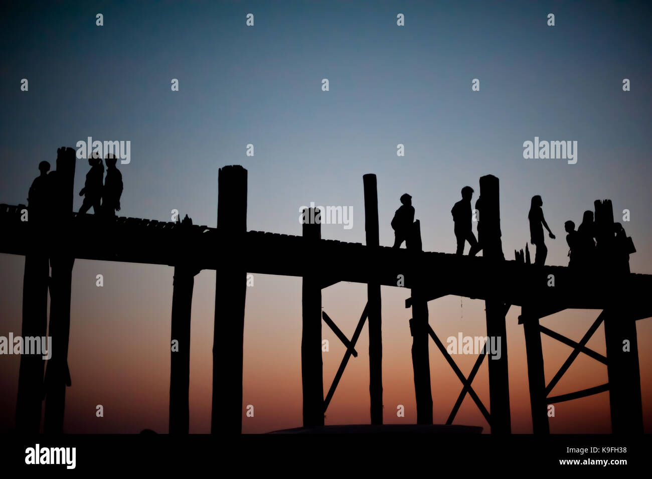 Incredibile paesaggio myanmar. vecchio ponte di legno u bain, realizzati in teak, amarapura, mandalay.. Alto contrasto silhouette foto, vista al tramonto, la gente a piedi. Foto Stock