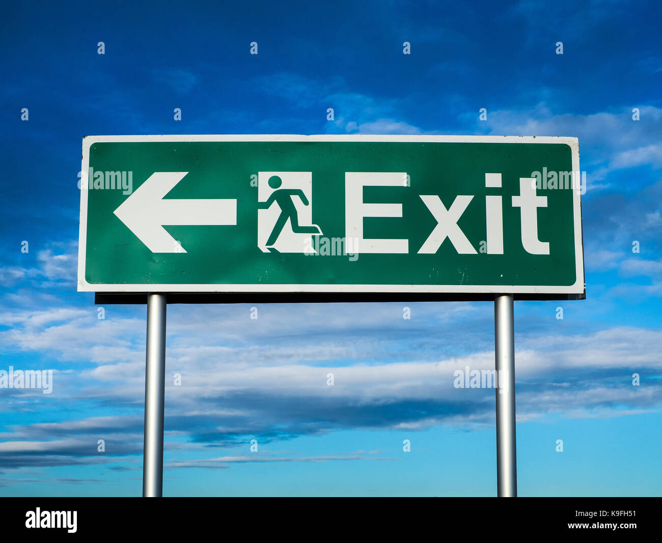 Uscita di emergenza segno contro un cielo blu Foto Stock