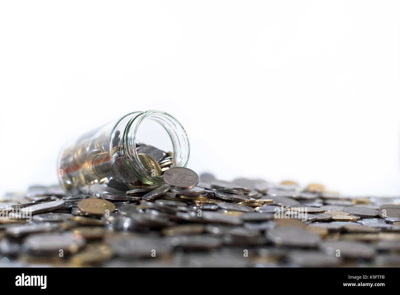 Il vasetto di vetro su un gruppo di monete isolati su sfondo bianco. concetto finanziario. malaysia valuta Foto Stock