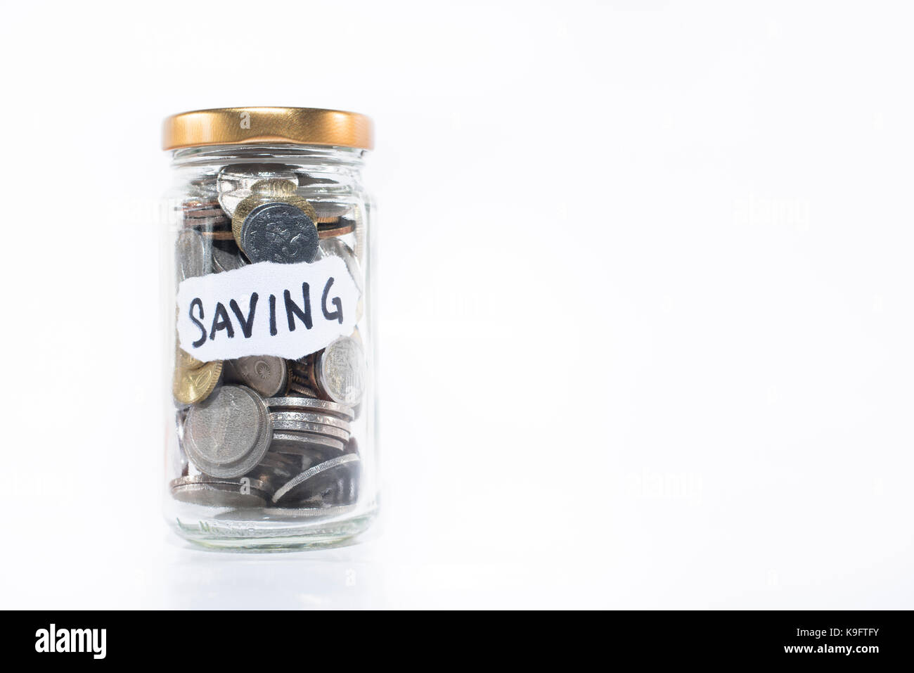 Monete in un vasetto di vetro con nota scritta ' risparmio ' isolato su sfondo bianco. copia libera spazio. concetto di risparmio. malaysia valuta Foto Stock