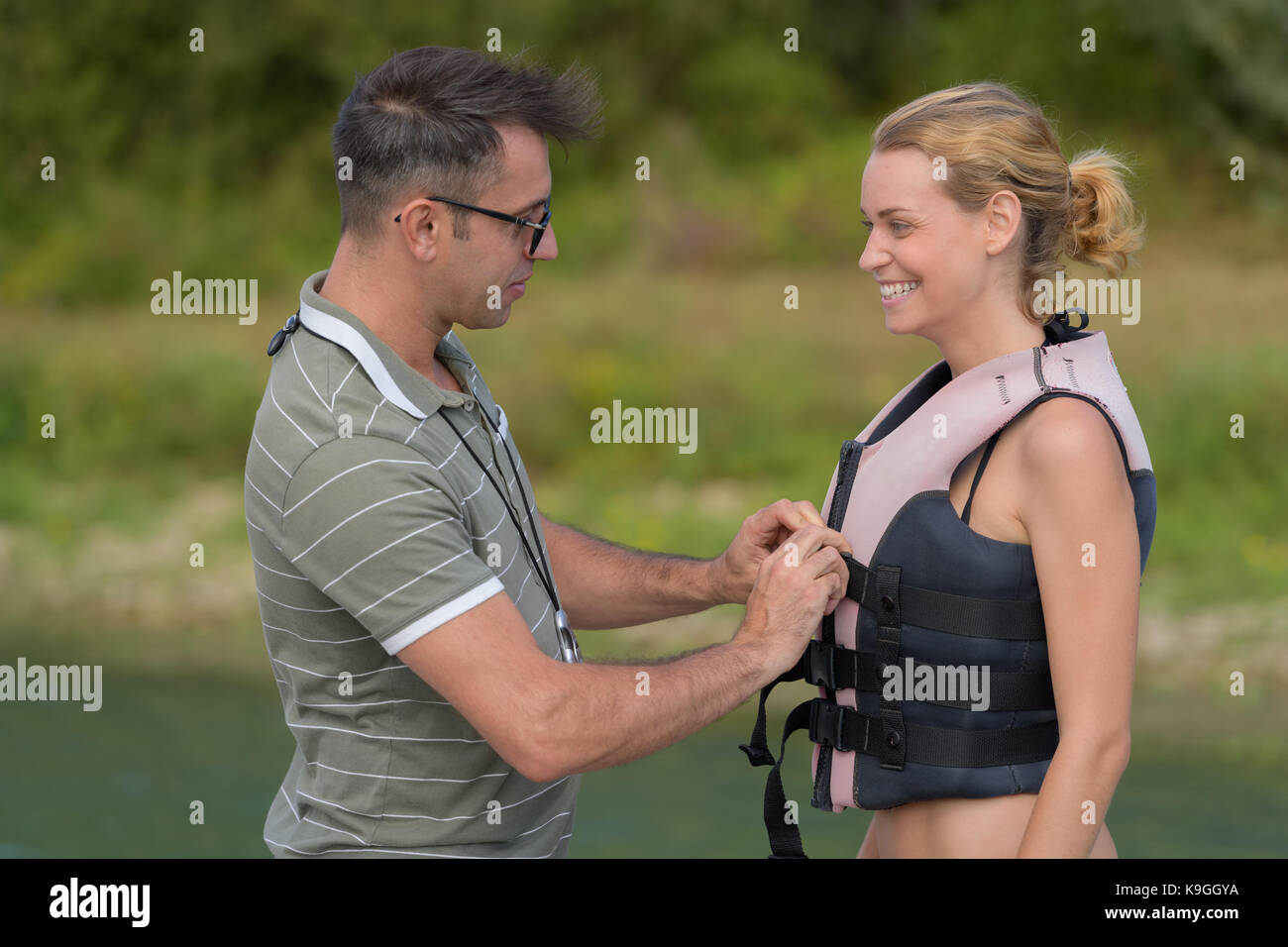 Donna che indossa un giubbotto di salvataggio prima di acqua lezione di sci Foto Stock