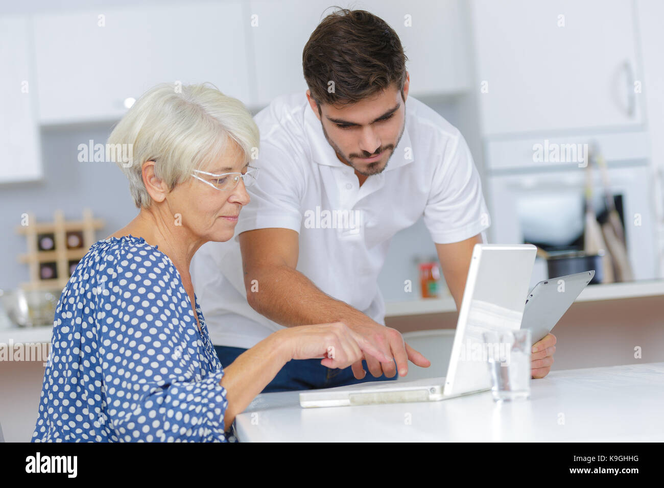 Giovane uomo aiutando la dama con il suo computer Foto stock - Alamy