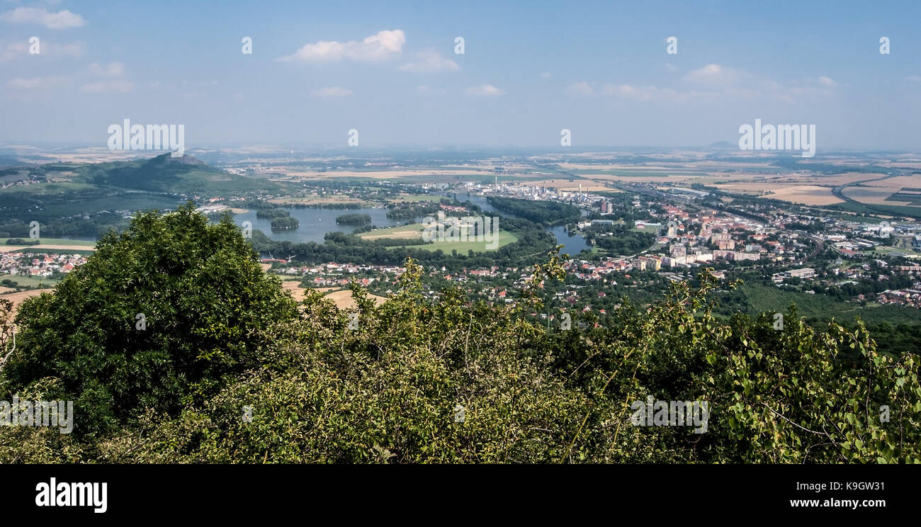 Vista di lovosice city con i villaggi intorno, zernosecke jezero, fiume Labe, radobyl hill e la campagna intorno da panenske kameny punto di vista ne Foto Stock