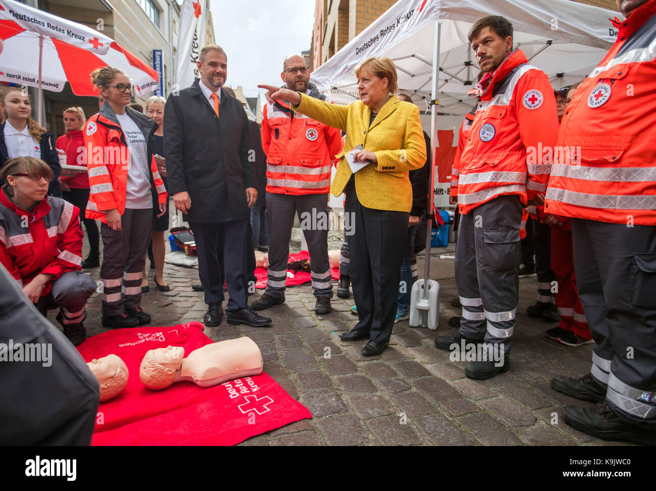 Stralsund, Germania. 23 Sep, 2017. Il cancelliere tedesco Angela Merkel riceve informazioni ad uno stand della Croce Rossa tedesca per il progetto settimana 'resuscitation' mentre passeggiando per il centro storico di Stralsund, Germania, 23 settembre 2017. Il progetto settimana dell'università di medicina di greifswald persone vengono insegnate resuscitarlo. Dopo la visita di Stralsund Merkel parteciperà anche raccolto una celebrazione in lauterbauch sull isola di ruegen, così come la città di Greifswald. Credito: Jens büttner/dpa-zentralbild/dpa/alamy live news Foto Stock