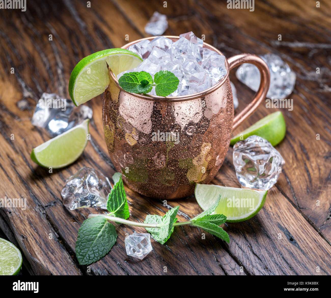 Moscow mule. frosty mug in rame con calce e cubetti di ghiaccio sul tavolo di legno. Foto Stock